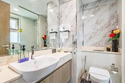 a bathroom with a sink and a toilet and a mirror at The Urban Retreat Elegant 3BR Townhouse Villanova in Dubai