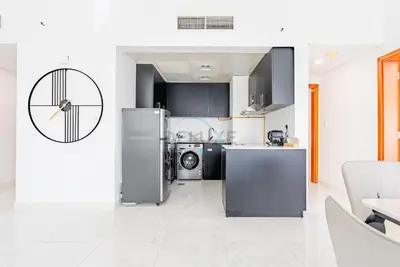 a kitchen with a refrigerator and a dishwasher at Lake-View Apartment Near City Centre Meaisem Mall, Just Minutes from Dubai Autodrome and ICC Cricket Stadium - The Crescent A, Dubai Production City by Deluxe Holiday Homes in Dubai