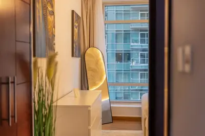 a room with a chair and a table and a window at Luxury 2BR in Downtown w Iconic Burj Khalifa View Burj Views 303 in Dubai