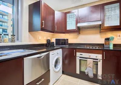 a kitchen with a washer and dryer in it at Spacious 1BR Apartment - The Jewels Tower 2 - Dubai Marina in Dubai