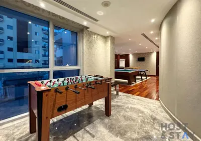 a living room with a foosball table and a pool at Spacious 1BR Apartment - The Jewels Tower 2 - Dubai Marina in Dubai