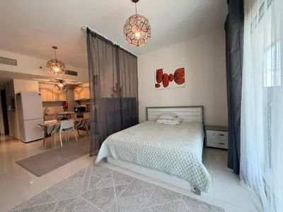 a bedroom with a bed and a kitchen at Convenient studio in the centre of Dubai in Dubai