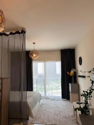 a bedroom with a bed and a large window at Convenient studio in the centre of Dubai in Dubai