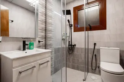 a bathroom with a shower and a sink and a toilet at Luxury 4 BHK Villa in JVC by dPie in Dubai