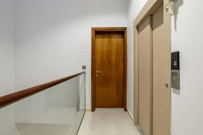 a hallway with a wooden door and a staircase at Luxury 4 BHK Villa in JVC by dPie in Dubai