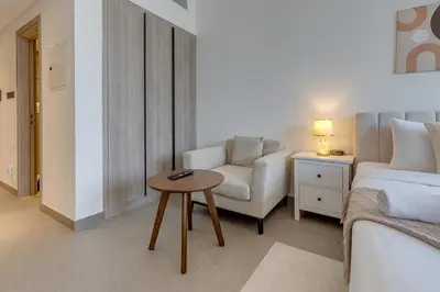 a living room with a bed and a table and a couch at Oxford Terraces, JVC - Studio Apartment - Allsopp & Allsopp in Dubai
