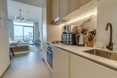 a kitchen with a sink and a counter top at Oxford Terraces, JVC - Studio Apartment - Allsopp & Allsopp in Dubai