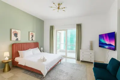 a bedroom with a bed and a blue couch at Premium Ensuite Room With Balcony in Dubai
