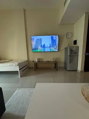 a living room with a flat screen tv on the wall at Modern Studio Apartment in Dubai Sports City in Dubai