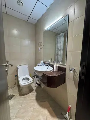 a bathroom with a toilet and a sink and a mirror at Modern Studio Apartment in Dubai Sports City in Dubai