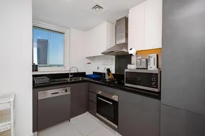 a kitchen with stainless steel appliances and a window at Canal Bliss Studio- DAMAC Maison Prive in Dubai