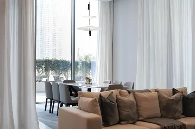 a living room with a couch and a table with chairs at BRAND NEW FULL MARINA VIEW 1BR Apartment at LIV Marina in Dubai