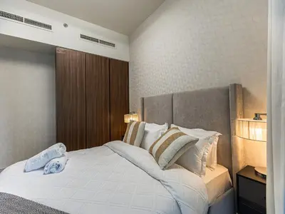 a bedroom with a large white bed with pillows at Centrally Located 1 BR in Damac Reva - 7 Min walk to Dubai Mall in Dubai