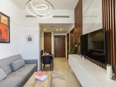 a living room with a couch and a large tv at Centrally Located 1 BR in Damac Reva - 7 Min walk to Dubai Mall in Dubai