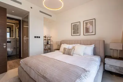 a bedroom with a large bed and a bathroom at Elegant 2-Bedroom Apartment with Stunning City and Water Views in Dubai
