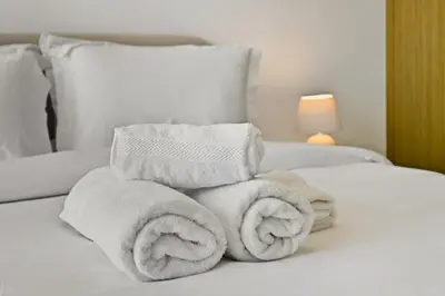 a pile of towels sitting on top of a bed at Estudio Noor en Dubai Por beBalmy in Dubai