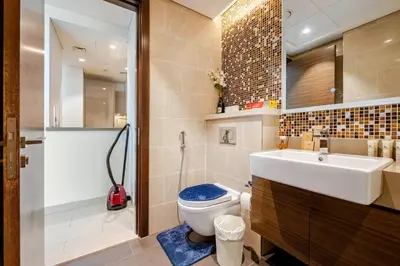 a bathroom with a toilet and a sink and a shower at Stunning I Biggest Studio I Near To Downtown in Dubai