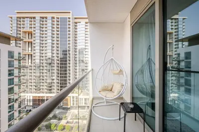 a balcony with a chair and a view of a city at Stunning I Biggest Studio I Near To Downtown in Dubai