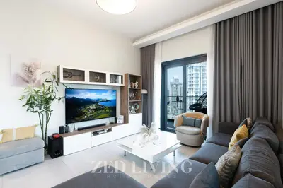 a living room with a couch and a tv at Sol Bay - Stay in style with Burj Khalifa views - Zed Living in Dubai