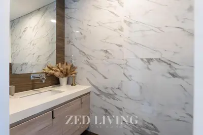 a white marble bathroom with a sink and a mirror at Sol Bay - Stay in style with Burj Khalifa views - Zed Living in Dubai