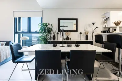 a dining room with a white table and chairs at Sol Bay - Stay in style with Burj Khalifa views - Zed Living in Dubai