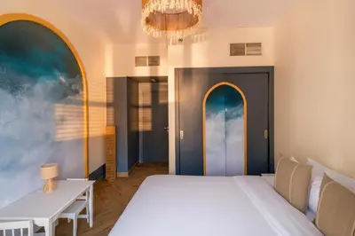 a bedroom with a bed and a table and a chandelier at Luxury 4 Bedroom Penthouse in Dubai Marina in Dubai