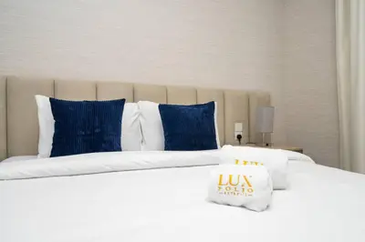 a large white bed with blue pillows in a bedroom at Dubai Hills Townhouse in Dubai