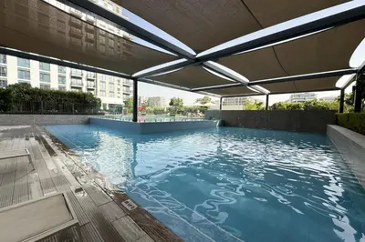a large swimming pool with a canopy on a building at Dubai Hills Townhouse in Dubai