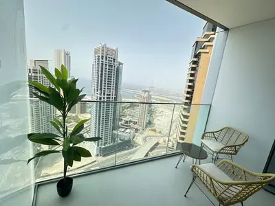 a room with a large window with a plant and chairs at Royal suite at Liv marina views in Dubai