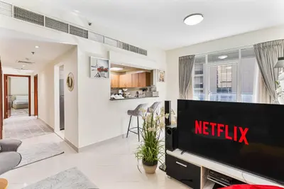a living room with a television in a living room at 2-Bedroom Haven with Canal View near The Els Club in Dubai