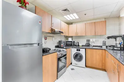 a large kitchen with a stainless steel refrigerator at 2-Bedroom Haven with Canal View near The Els Club in Dubai