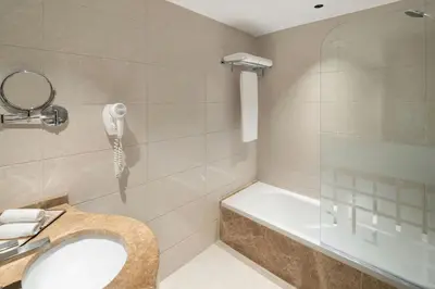 a bathroom with a shower and a sink and a phone at Vintage Grand Hotel Apartments Dubai in Dubai