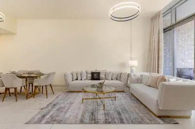 a living room with a white couch and a table at Maison Privee - Chic & Eclectic Family Home with Park Vws in Meydan in Dubai