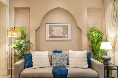 a living room with a couch with blue and white pillows at Charming 1 BR with Burj Khalifa View in Dubai