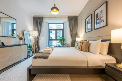 a bedroom with a large bed and a large window at Charming 1 BR with Burj Khalifa View in Dubai