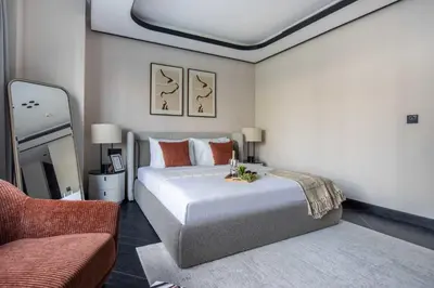 a bedroom with a large bed and a chair at Frank Porter - J One Tower 2 in Dubai