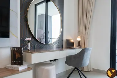 a dressing table with a mirror and a chair at Vogue JVC Binghatti Dawn near Circle Mall, Studio Apartment with Balcony and Vibrant Community View, Access to all Amenities in Dubai