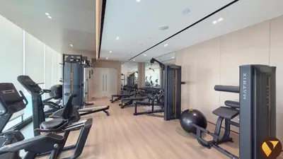 a gym with a bunch of treadmills and machines at Vogue JVC Binghatti Dawn near Circle Mall, Studio Apartment with Balcony and Vibrant Community View, Access to all Amenities in Dubai