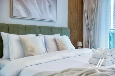 a white bed with white pillows in a bedroom at Luxury 2BR Harbour Views Tower 2 Creek Harbour Dubai in Dubai