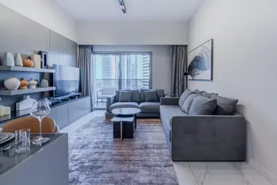 a living room with a couch and a tv at TRPS - MAG 318, Business Bay - Pool View, 2BR Fully Furnished, Prime Location in Dubai