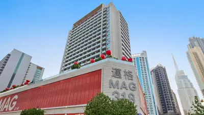 a building with christmas decorations on top of it in a city at TRPS - MAG 318, Business Bay - Pool View, 2BR Fully Furnished, Prime Location in Dubai