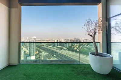 a room with a large window with a potted plant at Samaya Holiday Homes - Square 1B Duplex Panoramic View in Dubai