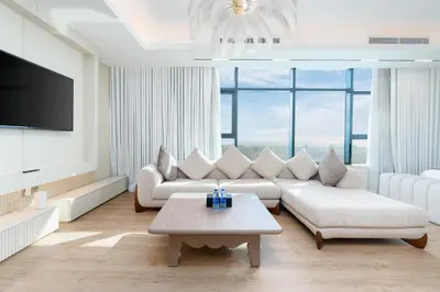 a living room with white furniture and a large window at Samaya Holiday Homes - Square 1B Duplex Panoramic View in Dubai