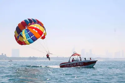 a group of people on a boat in the water with a parachute at Parasailing Boat Dubai in Dubai