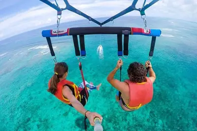 two people in the water on a swing in the water at Parasailing Boat Dubai in Dubai