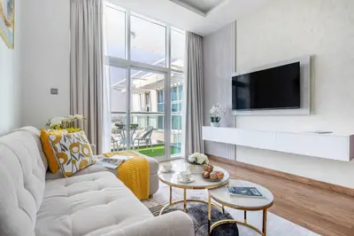 a living room with a white couch and a tv at Frank Porter - Glitz Residence 2 in Dubai