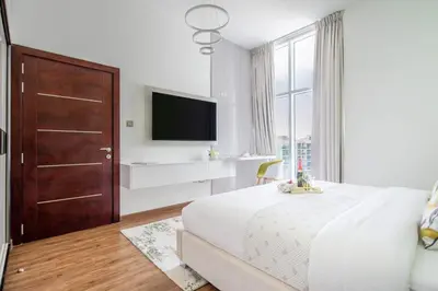 a bedroom with a large bed and a tv at Frank Porter - Glitz Residence 2 in Dubai