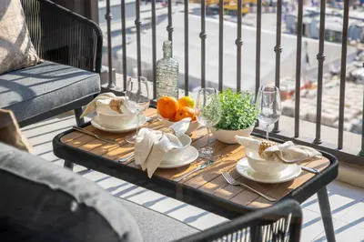 a table with food and wine glasses on a balcony at Frank Porter - Jadeel 3 in Dubai