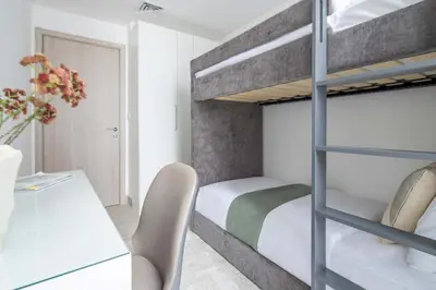 a bedroom with a bunk bed and a desk at Frank Porter - Luma22 West Tower in Dubai