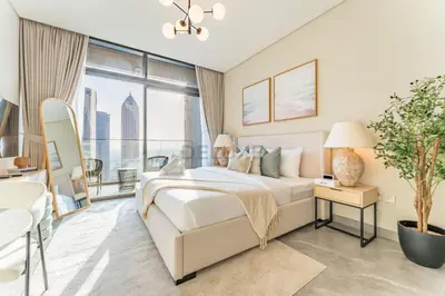 a bedroom with a bed and a large window at Studio with Dubai Canal View, Walking Distance to Metro Station and Near Downtown Dubai - Peninsula One, Business Bay by Deluxe Holiday Homes in Dubai